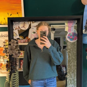 Mörkgrön half zip sweatshirt 157 - Mörkgrön sweatshirt från 157 i storlek S med half zip och hög krage. Tröjan har långärmade muddade ärmar och är gjord i mjuk bomullsmix. Perfekt för chill dagar och enkel att matcha med jeans eller leggings. Snygg loose passform och stilren design utan mönster.