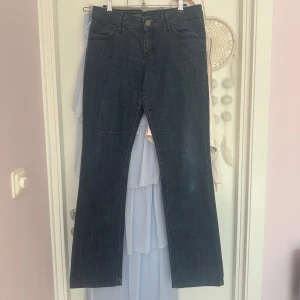 Mörkblå bootcut jeans - Snygga mörkblå jeans med bootcut passform och klassiska fickor. Jeansen har en rak midja och är tillverkade i ett robust denimtyg. 