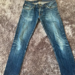Nudie selvedge jeans  - Intressekoll på mina nudie selvedge jeans. Flitigt använda så har de fått en unik look. De har några lagningar, men väldigt bra skick i övrigt. Dessutom oändligt gratis lagningar med nudie. Grim Tim 34/34, men sitter något mindre. Kom med prisförslag! 