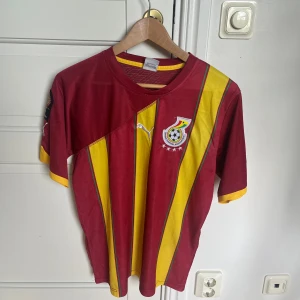 Ghana fotbollströja Puma röd/gul - Ghanas riktigt feta tröja från något år efter de gick till semin 2010. Pris går att diskutera vid snabb affär, hämtas vid Barkarby stadion eller fraktas där du står för frakten.