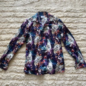 Skjorta från Eton, slim fit - Skjorta från Eton i slim fit med blommigt mönster i blått, lila, orange och vitt. Skjortan har långa ärmar, klassisk krage och knappar framtill. Materialet är mjuk bomull som känns skönt mot huden. Perfekt för dig som gillar att sticka ut med din stil. Storlek 40