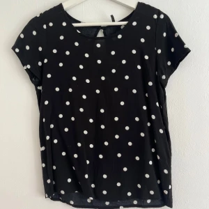 Blus - Svart blus från ONLY med vita prickar. Blusen är använd men trots detta i väldigt fint skick. Den är i ett skönt och luftigt material 