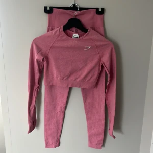 Rosa kit från Gymshark - Säljer ett par rosa seamless leggings från Gymshark med hög midja och tight passform. Säljs tillsammans med matchande tröja. Båda i storlek S. 