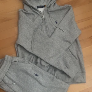 Ralph Lauren Tracksuit - En Ralph Lauren Tracksuit i färgen grå. Hela setet är i typ nyskick. Storleken är L men den passar mer som M. Säljs då den inte passade i storlek. Vid fler frågor är det bara att höra av sig utan tveka 😊! Priset kan diskuteras vid snabb affär. 149kr rabbat ifall ni börjar följa plick kontot!!