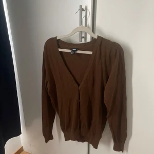 Brun kofta - Säljer en brun kofta från H&M i storlek S. Materialet är mjukt och tröjan är i fint skick!🥰🥰