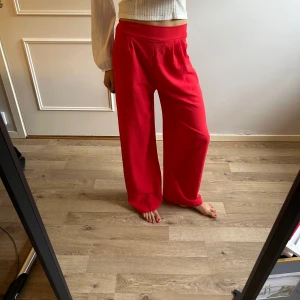 Röda wide byxor  - Snygga röda byxor i storlek 36. De har en bred resår i midjan och ett loose, wide fit med raka ben. Säljer då de var lite för stora 