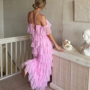 Ljusrosa volangklänning med axelband - Säljer en drömmig ljusrosa långklänning med flera lager volanger i tunn tyll. Klänningen har smala axelband, offshoulder-detalj och en snygg snörning i ryggen. Nyskick. Nypris 999 