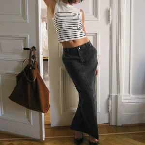 Svart lång jeanskjol från NA-KD - Trendig svart långkjol i jeans från NA-KD med hög midja och rak passform. HELT NY! Ej använd!