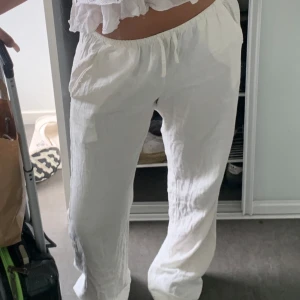 Vita linnebyxor med snörning - Säljer ett par fräscha vita linnebyxor med avslappnad passform och resår i midjan. Byxorna har snörning och raka, vida ben. Jag köpte dem från madlady för en månad sen men känner inte behovet att ha kvar dem så jag säljer vidare dem. Jag är 172 och dem är för långa på mig. Storlek S/Tall. Köpte dem för 599kr