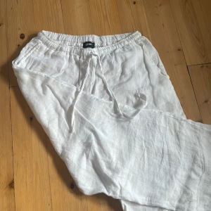 Vita linnebyxor från Define - Säljer ett par fräscha vita linnebyxor från Define. Byxorna har resår i midjan och snörning för extra bekväm passform. Perfekta för varma dagar och chill vibes. Lätta och luftiga med raka ben och sidfickor. Använda fåtal gånger och i nytt skick utöver att dom är lite skrynkliga❤️
