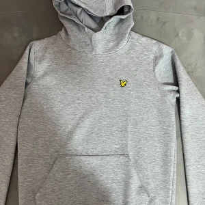 Grå Lyle & Scott hoodie - Säljer enLyle & Sctt grå hoodie den är jättefin,den är knappt använt helt ny hoodie vill sälja pågrund av att jag har många kläder i min garderob. 