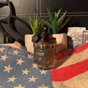 Spicebomb parfym från Viktor & Rolf - Spicebomb från Viktor & Rolf är en ikonisk herrparfym i en cool, granatinspirerad flaska med transparent glas och svart detaljer. Flaskan har en metallisk svart ring och etikett, vilket ger en edgy och modern vibe. Perfekt för dig som gillar kryddiga och intensiva dofter. Helt full. Passar perfekt nu inför hösten och vintern. Kommer inte med förpackning.