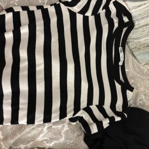 Svartvit randig t-shirt från Zara - Snygg svartvit randig t-shirt från Zara med klassisk rund hals och korta ärmar. Perfekt för dig som gillar enkel men stilren design. Mjukt material som känns skönt mot huden och passar till jeans eller shorts.
