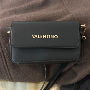 Svart axelväska från Valentino - Svart liten väska från Valentino, köpt på zalando för ungefär ett år sedan. Den är aldrig använd då jag hittade en annan väska. 