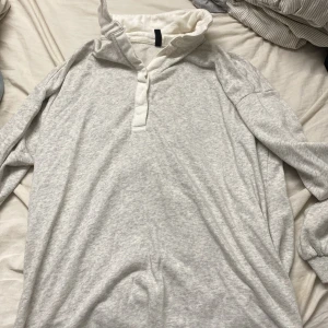 Ljusgrå pikétröja från H&M Divided - Ljusgrå långärmad pikétröja från H&M Divided i mjuk bomull. Tröjan har klassisk krage med knappar och relaxed fit. Perfekt för dig som gillar en enkel och clean stil. Passar till jeans eller mjukisbyxor.