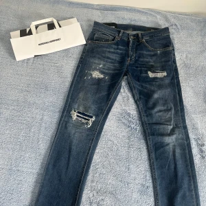 Dondup jeans blå💙 - Säljer ett par blå jean från Dondup🔥 storlek 29. modellen är  George‼️ jeansen har coola slitningar och trasiga detaljer på benen. Perfekta för dig som gillar en trendig och avslappnad look. Priset är inte hugget i sten 🪨 