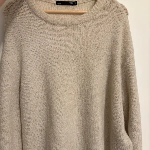 Beige stickad tröja XL från Lager157 - Mysig beige stickad tröja från Lager 157 i storlek XL. Tröjan har en rund halsringning och långa ärmar, perfekt för lager-på-lager och chill dagar. Enkel och stilren design som funkar till det mesta. Aldrig använd