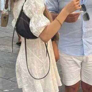 Vit kortklänning från Adoore - Superfin vit kortklänning från Adoore med broderade blommor, v-ringning och puffärmar. Klänningen har knappar framtill och är sydd i ett lätt tyg med romantisk känsla.