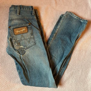 Wrangler jeans - Lågmidjade wrangler jeans med patchwork överallt! Dom är i mycket bra skick och passar XS/S!