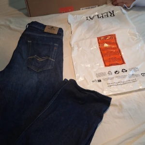 Mörkblå jeans från Replay - Säljer ett par mörkblå jeans från Replay med klassisk femficksdesign och snygga kontrastsömmar. Jeansen har en rak passform och är tillverkade i slitstarkt denimtyg. Perfekta för dig som gillar stilrena och tidlösa jeans. Modellen på jeansen är Thad och box medföljer, om du vill se kvitto hör gärna av dig🙌🏼 nypris: 799kr. Jeansen har endast använts ett fåtal gånger då de inte passade mig. Mitt pris: 400kr, hör av dig vid funderingar eller frågor, priset är inte hugger i sten🙏🏼🙌🏼