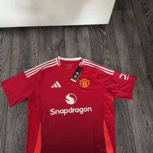 Manchester United röd Adidas tröja L - Manchester Uniteds officiella matchtröja från Adidas i rött med vita detaljer, storlek L priset står i sten!