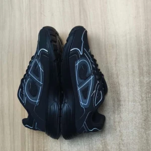 Svarta Dior sneakers med vita detaljer - Snygga svarta Dior sneakers med vita och silvriga detaljer samt CD-logga bak. Skorna har snörning, rund tå och en chunky platt sula. Materialmix av mesh och syntet ger en modern vibe. Perfekta för dig som vill sticka ut med exklusiva och trendiga sneakers.