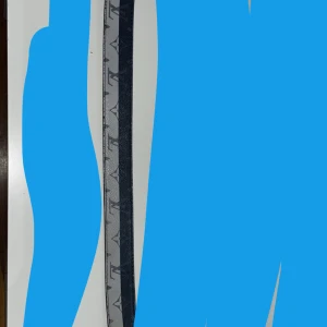 Grått skärp med svart mönster - Snyggt grått bälte med svart grafiskt mönster längs hela bandet. Bältet är smalt och har en stilren look som passar till jeans eller byxor. Materialet är troligtvis syntet eller skinnliknande. Perfekt accessoar för att lyfta din outfit.