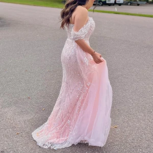 Ljusrosa glittrig balklänning - Magisk ljusrosa långklänning med glittriga paljetter och offshoulder-ärmar. Klänningen har en superfin passform, vacker släp och transparenta detaljer. Perfekt för bal eller student. Tyll och paljetter ger en lyxig känsla och den axelbandslösa designen är superfin. Första ägare. Priset kan diskuteras 💞
