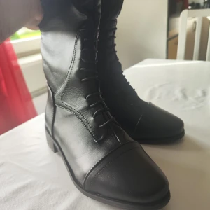 Svarta höga ridstövlar i skinn - Snygga svarta höga ridstövlar köptes för ett tag sen aldrig använd för de var för stora för mig storlek 37 jätte fint i skick 