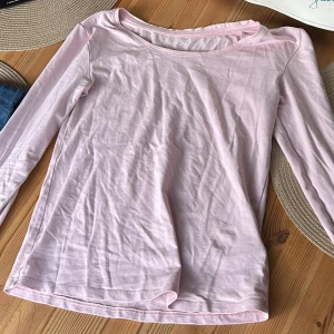 Ljusrosa långärmad tröja 157 XS - Ljusrosa långärmad tröja från Lager 157 i mjuk bomullsblandning med lite stretch. Enkel och clean design med rund halsringning, perfekt att styla med jeans, och med ett par mjukisar eller kjol. Skön passform och tunn, följsam känsla. 