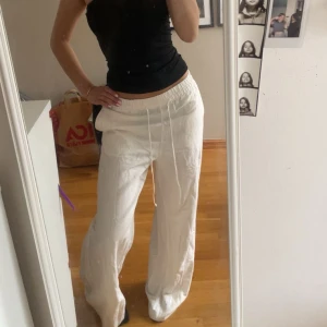 Vita linnebyxor  XS - Säljer ett par vita linnebyxor med bred resår i midjan och snörning framtill. Byxorna har en loose och wide passform med raka, långa ben. Man kan använda byxorna med både resåren in vikt (bild 1) och inte vikt (bild 2). Dem är köpta för bara någon månad sen men har inte kommit till användning, skicket är därför som nytt. 