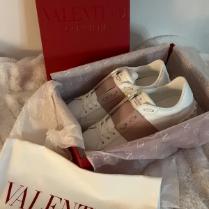 Valentino Garavani Open sneakers vit/rosa - Intressekoll på dessa helt nya valentino skor, i damstorlek 37 i modellen open. Säljer de eftersom dem var för stora för mig och kan inte returnera dem. Nypriset var runt 8200 kr men jag säljer för 5900 kr💕Allt på bilden tillkommer + snören och ett kort från Valentino🫶🏼