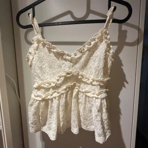 Vit spetsig linnetopp med volang - Supersöt vit linnetopp i spets med volangdetaljer och smala axelband. köpt i usa! 🇺🇸 