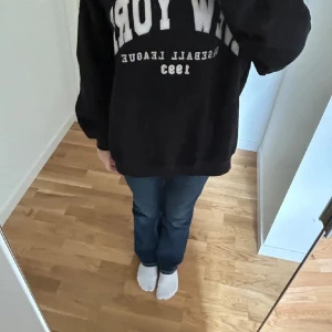 Svart sweatshirt från Bershka - Svart oversized sweatshirt från Bershka med vit text framtill. Tröjan har rund hals, långa ärmar och mjuk insida. Perfekt för en chill och sportig look.