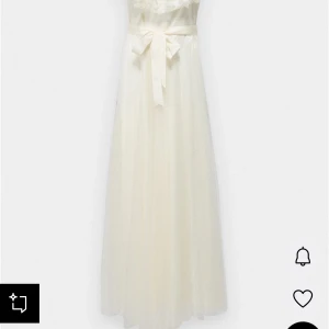 Bröllopsklänning Ida Sjöstedt  - Bröllopsklänning från Ida Sjöstedt i storlek 36. Endast provad. Nypris 8000 kr. Romantisk vit långklänning med offshoulder och stora volangdetaljer upptill. Klänningen har ett diskret prickigt mönster, markerad midja med knytband och luftig kjol. 