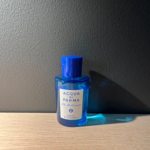 Acqua di Parma Blu Mediterraneo Mirto di Panarea parfym - Fräsch parfym från Acqua di Parma i serien Blu Mediterraneo, doften Mirto di Panarea. Flaskan är blå med rund form och har ett blått lock. Etiketten är vit med blå text. Perfekt för dig som gillar friska och marina dofter.