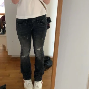 Svarta Ltb jeans - Säljer ett par snygga gråsvarta jeans med slitningar från Ltb. Jeansen är bootcut och har en låg midja och klassisk femficksdesign🥰💗