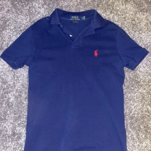 Mörkblå pikétröja från Polo Ralph Lauren - Säljer nu min polo piké då jag aldrig använt den. Köpte den på NK i Göteborg i somras och har bara använt den 1-2 gånger har kvitto. Storlek Xs och den är en ganska tajt tröja 