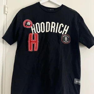 Svart t-shirt från Hoodrich med patches - Hoodrich T-shirt som inte används, passar kvinna som man men är i mans storlek!