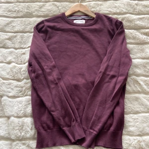 Vinröd tröja från Pier One - Säljer en stilren vinröd tröja från Pier One. Tröjan har rund halsringning och långa ärmar, perfekt för lager-på-lager. Materialet känns mjukt och passar bra till både jeans och chinos.