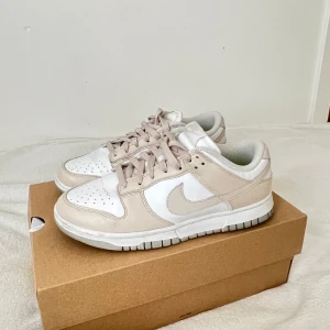 Nike Dunk Low beige och vita sneakers - Säljer ett par Nike Dunk Low som bara använts ett fåtal gånger. Skorna är i mycket fint skick med endast minimala spår av användning – sulan är fräsch och ovandelen i bra skick. 