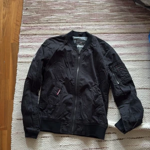 Svart bomberjacka från Superdry - Det står Large men det passar bättre för folk i mindre storlekar. Superdry, skön insida. 