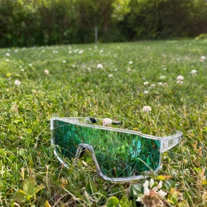 Sportiga blåtonade solglasögon - Säljer ett par sportiga solglasögon med spegelblå lins och transparent båge. De har en futuristisk, rektangulär form och passar perfekt för utomhusaktiviteter. Kommer med ett svart fodral för enkel förvaring.