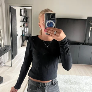 Svart långärmad topp  - Enkel svart långärmad topp i mjuk bomull med rund halsringning. Snygg croppad passform som funkar till allt och är lätt att styla med jeans eller kjol. Perfekt basplagg för garderoben. Hör av dig om du har några frågor eller funderingar! 🩷