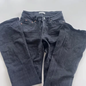 Svarta bootcut jeans mid rise - Snygga svarta jeans med bootcut-ben och mid rise. Klassisk femficksmodell med knapp och dragkedja framtill. Jeansen har en mörk tvätt och är tillverkade i ett mjukt denimtyg som sitter skönt hela dagen.