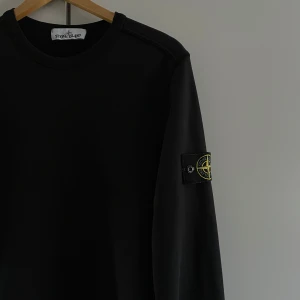 Stone Island Sweatshirt (ÄKTA) - Säljer en svart sweatshirt från Stone Island. Priset kan diskuteras då tröjan har lite defekter (lite små hål på 2 ställen) , så priset är ej hugget i sten. Tröjan är såklart autentisk och kvitto finns! Tveka inte på att höra av dig vid frågor!! 