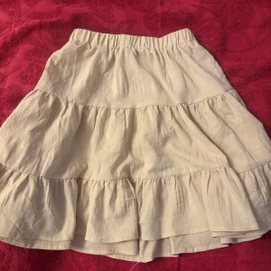 Beige volangkjol med resårmidja - Supersöt beige kortkjol med flera volanger och resår i midjan