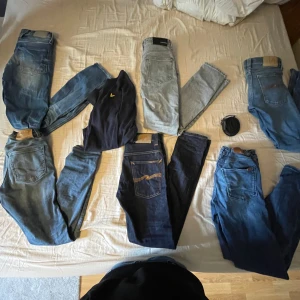 Flera par jeans i olika blå nyanser alla utom de högst uppe i hörnet  - Säljer flera par jeans i olika blå och grå nyanser. Modellerna varierar från ljusgrå till mörkblå denim, vissa med klassiska bakfickor och kontrastsömmar. Perfekta för dig som gillar jeans i olika tvättar och stilar.