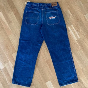 Butter Goods Jeans - Säljer ett par blå jeans från Butter med relaxed loose fit. Jeansen har broderad Butter-logga på fickan, snörning i midjan och raka ben. Det står 32 men då den är justerbar passar den mig som är 30 och mindre storlekar. Bara en liten defekt på bild 4. Pris inte satt i sten.