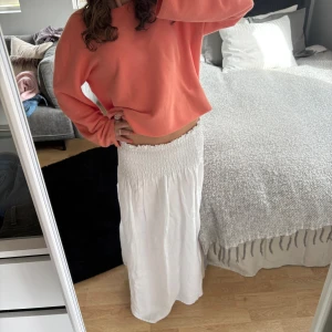 Vit långkjol med ribbad midja  - Säljer en vit långkjol med ribbad midja som ger en snygg och bekväm passform. Kjolen är luftig och enkel att styla med både crop tops och stickade tröjor.🌷🤍